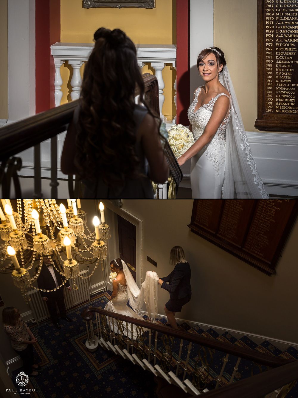 Wedding photography session on elegant staircase with crystal chandelier.