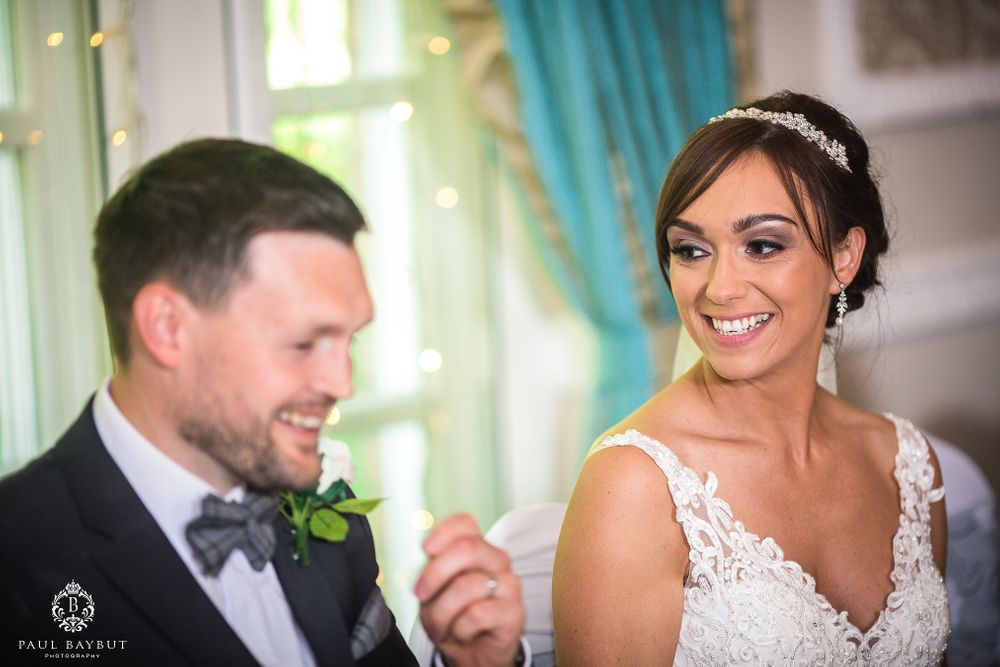 Candid moment of joy shared between couple during wedding reception.