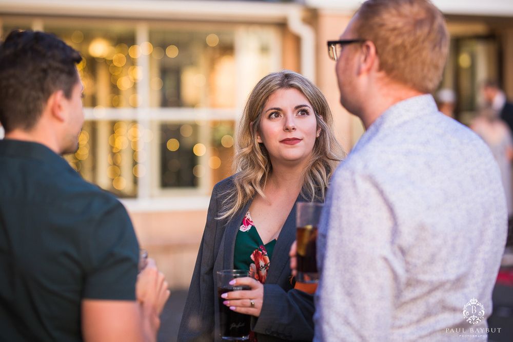 Casual evening gathering with people enjoying drinks and conversation.