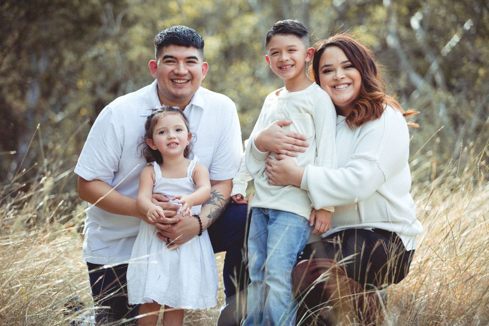 Casual outdoor family photo session in a field of tall grass.