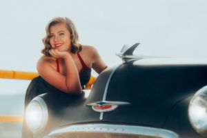 Vintage-style portrait with classic black car featuring chrome details.