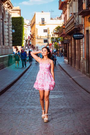 A pink floral dress stands out against the cobblestone streets of a charming European town.
