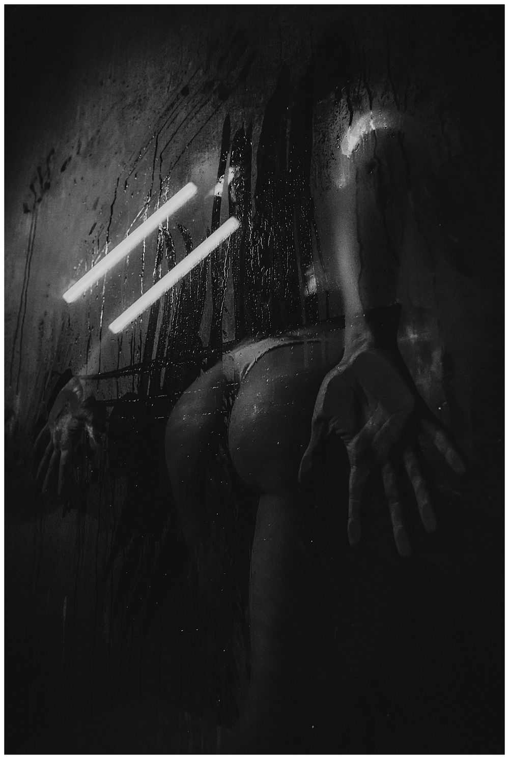 Dark atmospheric scene with bright light beams cutting through shadows.