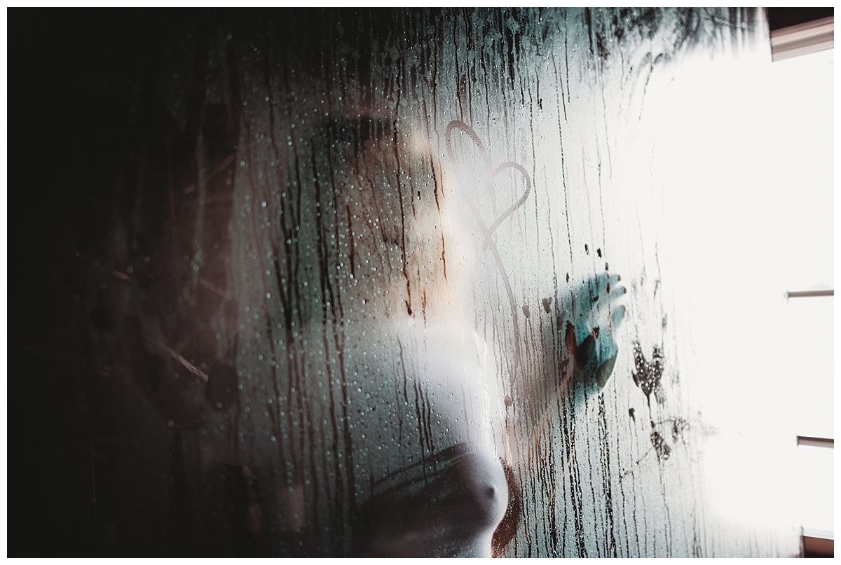 Textured surface with condensation or water droplets creating ethereal pattern in light.