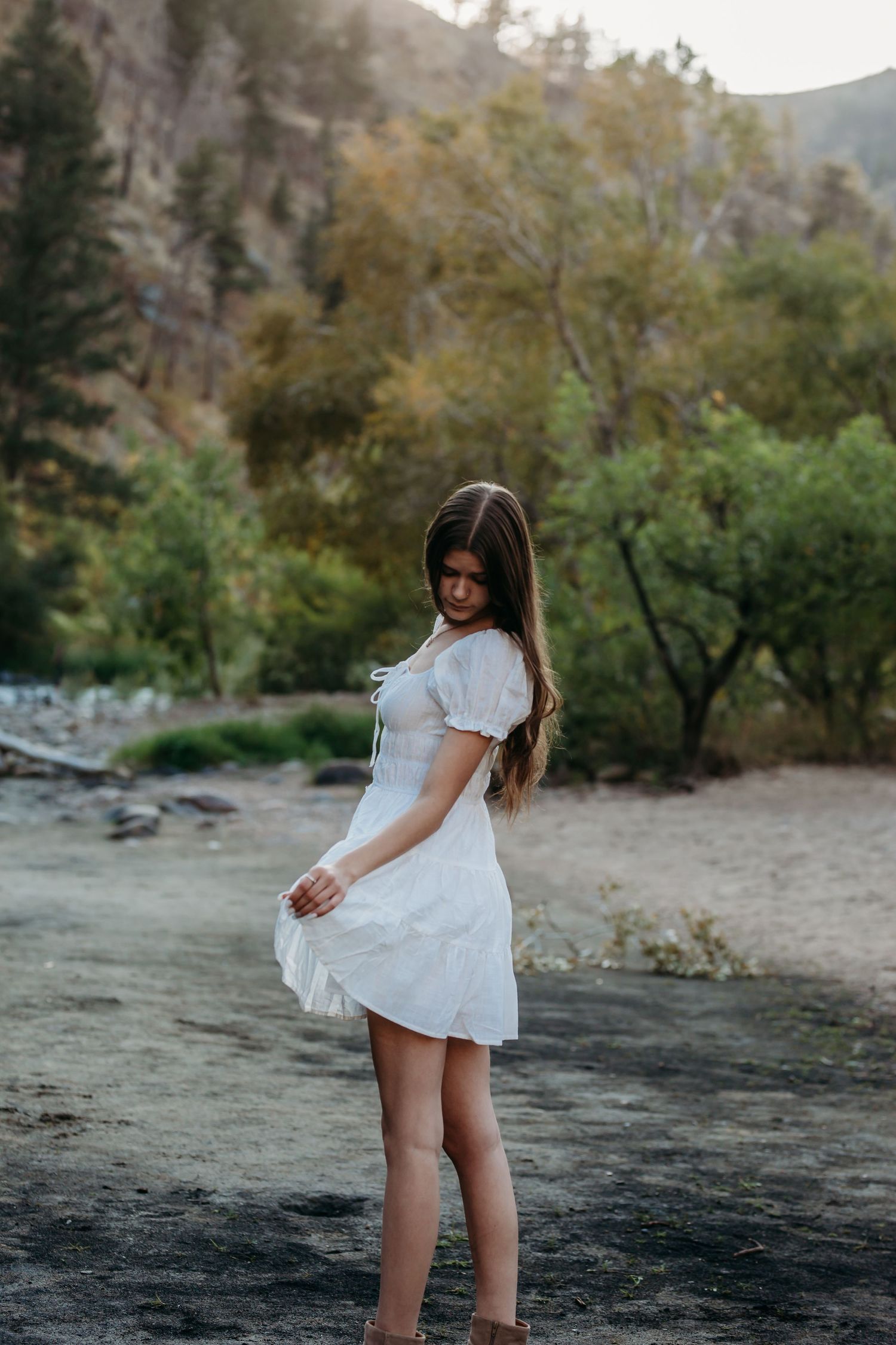 A white summer dress flows in the breeze near a mountain stream on a sunny afternoon.