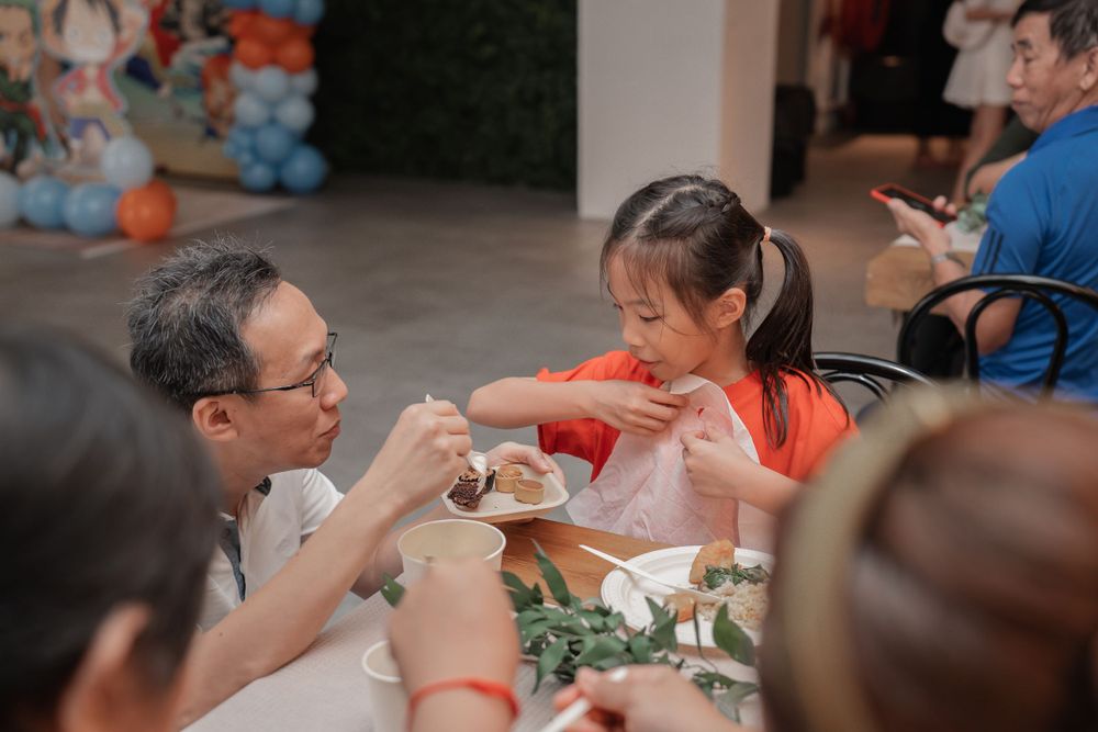 Diners share food and conversation at a decorated table during a social gathering.