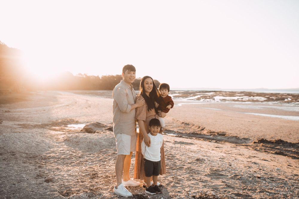 Family walking together along a scenic beach during sunset.
