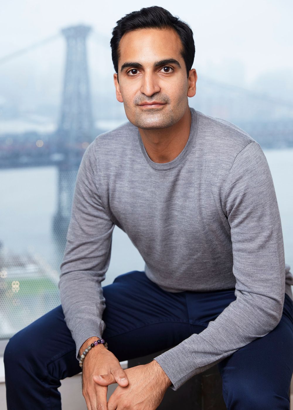 Portrait of a man in a gray longsleeve on the background of the bridge