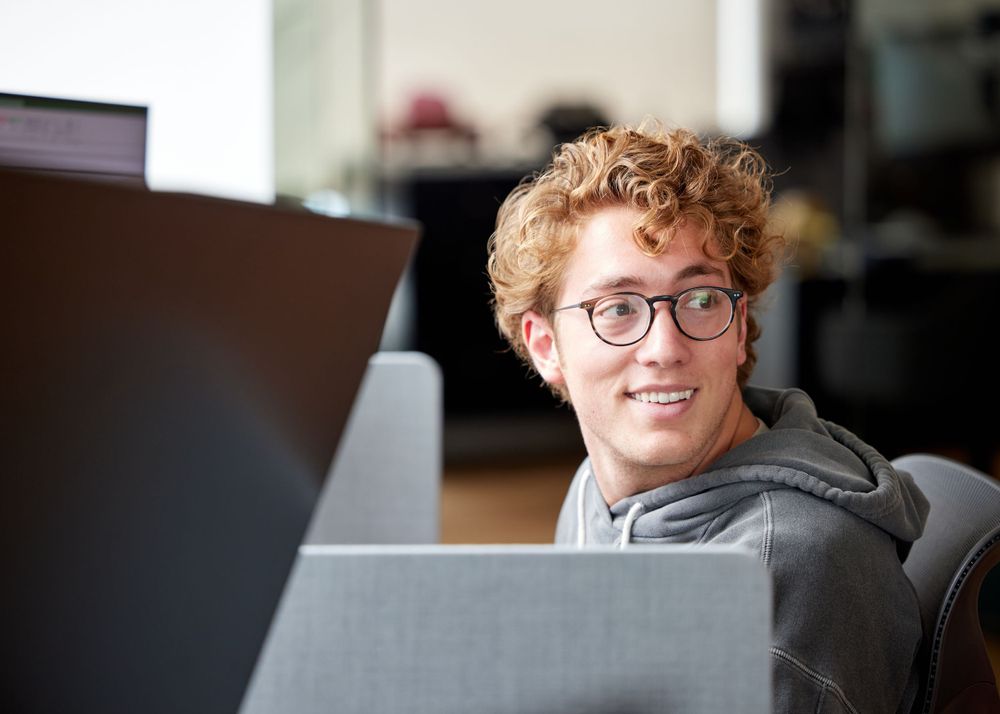 Young man in a office look behind his back
