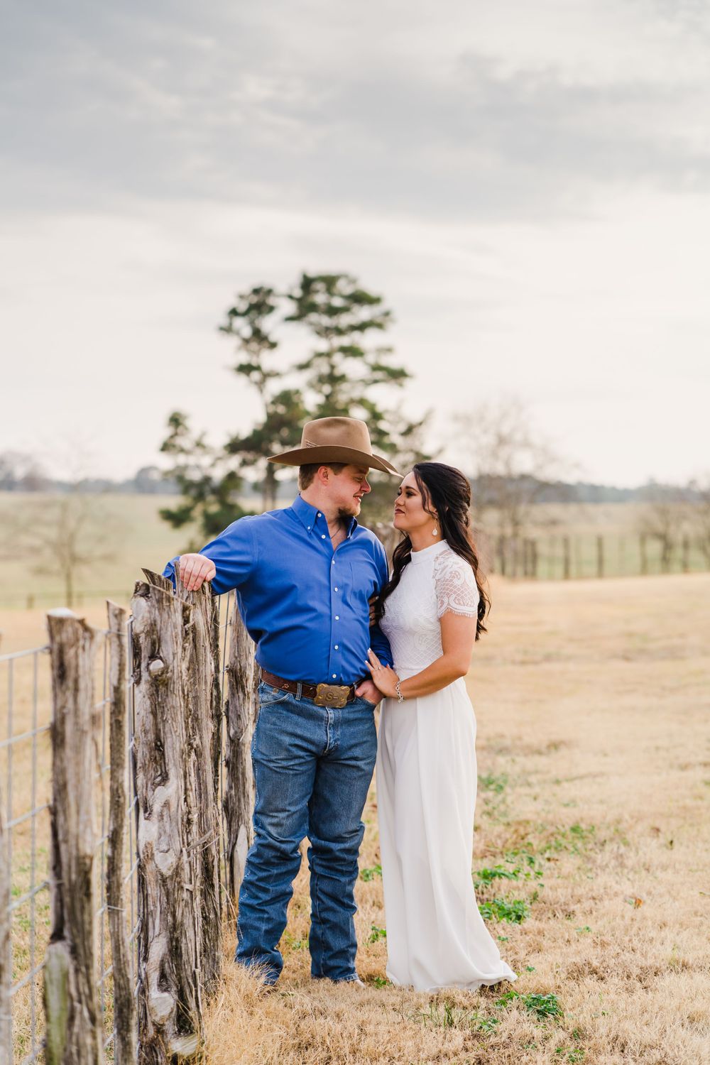 Romantic countryside portrait by wooden fence posts with rolling hills in background.