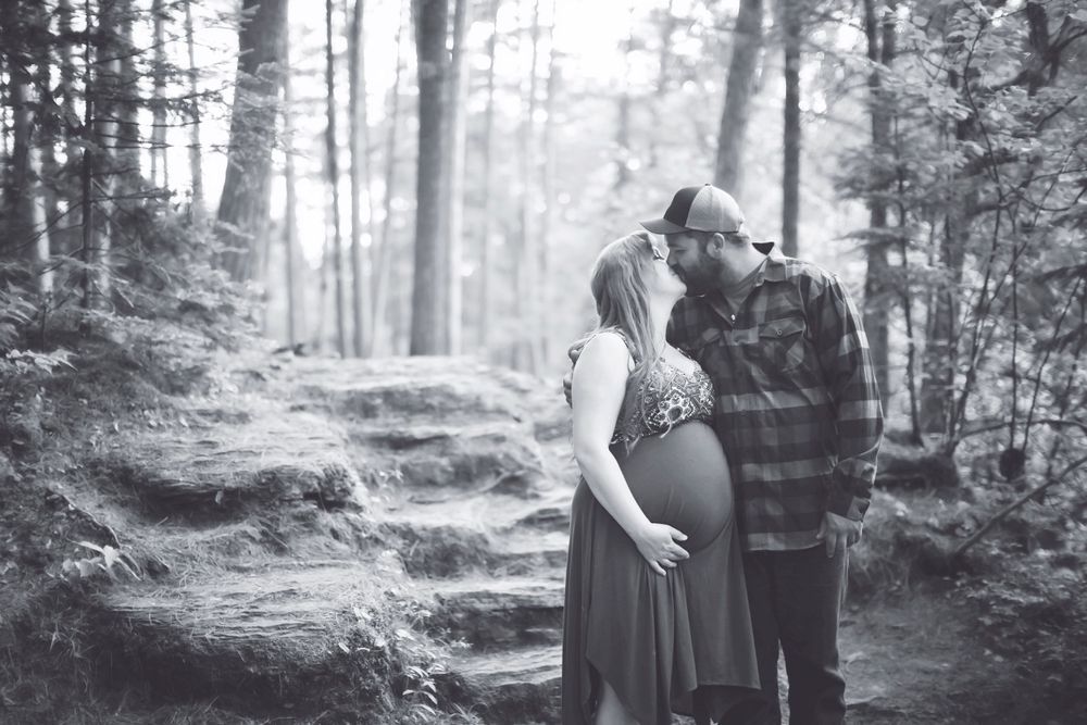 A couple embraces on a misty forest path during a maternity photoshoot in black and white. Amnicon Falls  Family Portraits