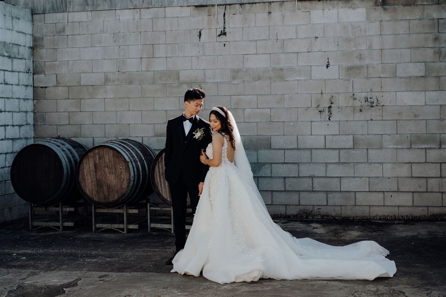Bride and groom posing in front of brick wall