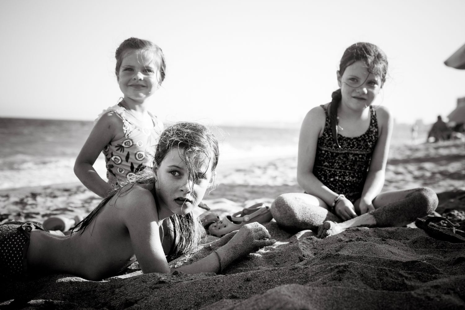 Three sisters playing on the beach at sunset time.