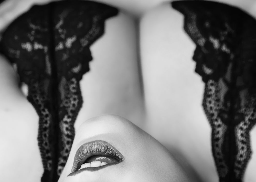 Artistic close-up black and white photo showing eye makeup and lace details.