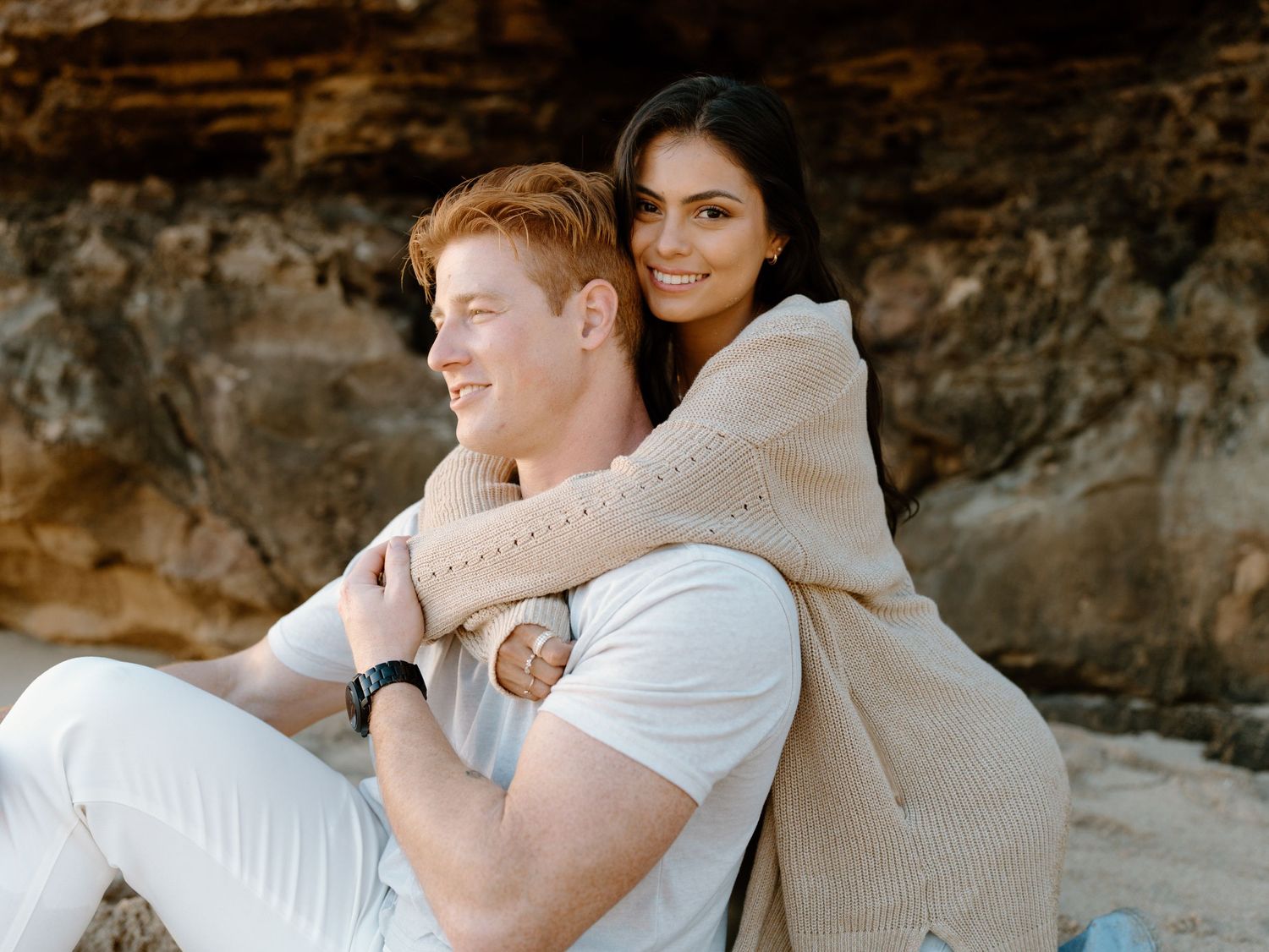 Couples photoshoot session by Moments With Kell on Oahu in Hawaii of a woman holding a man from behind on the beach
