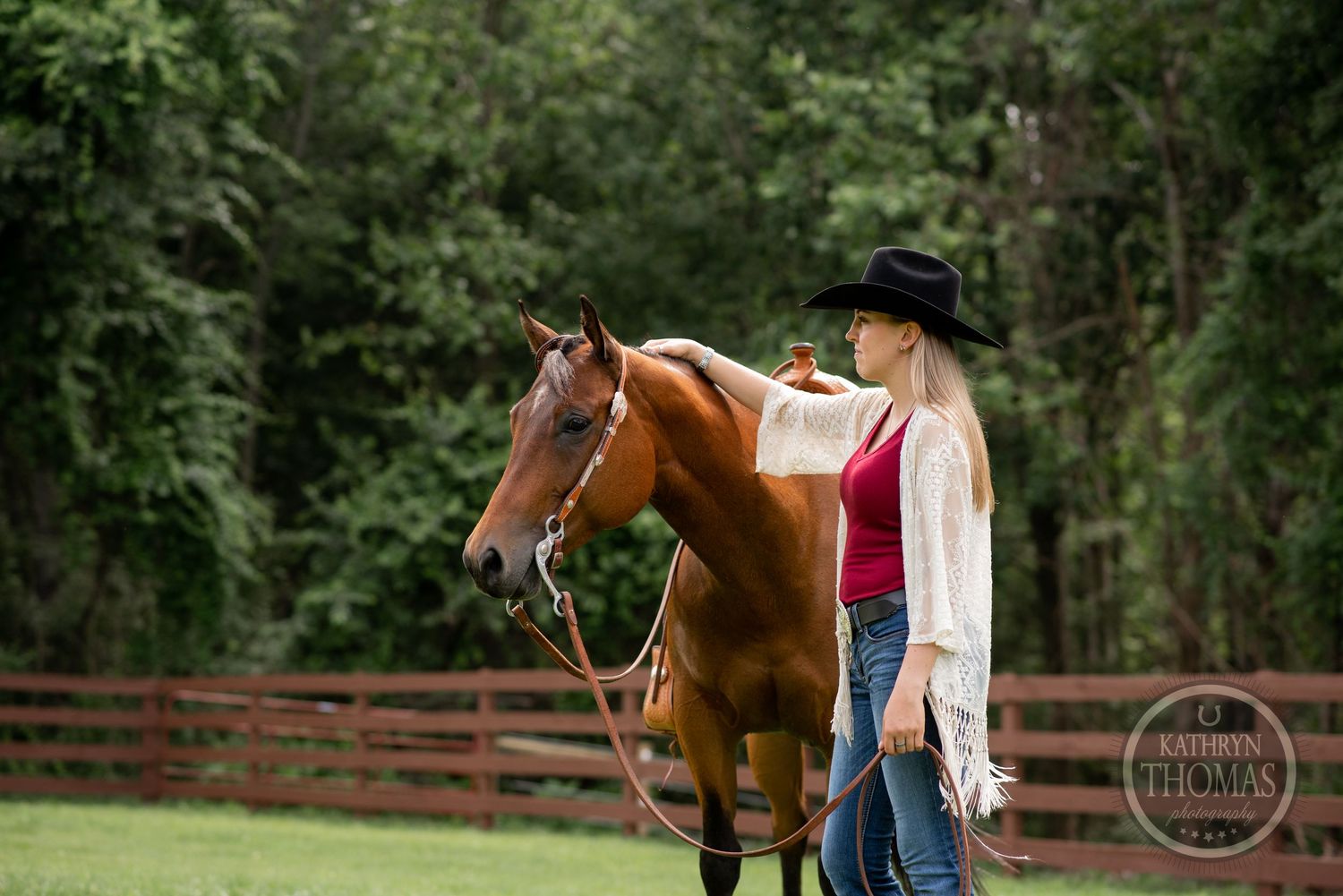 Western style equestrian stands with a chestnut horse near wooden fence in outdoor setting.