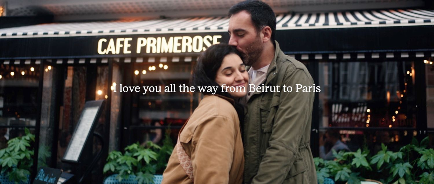 A romantic scene outside Cafe Primerose with a love message overlaid.