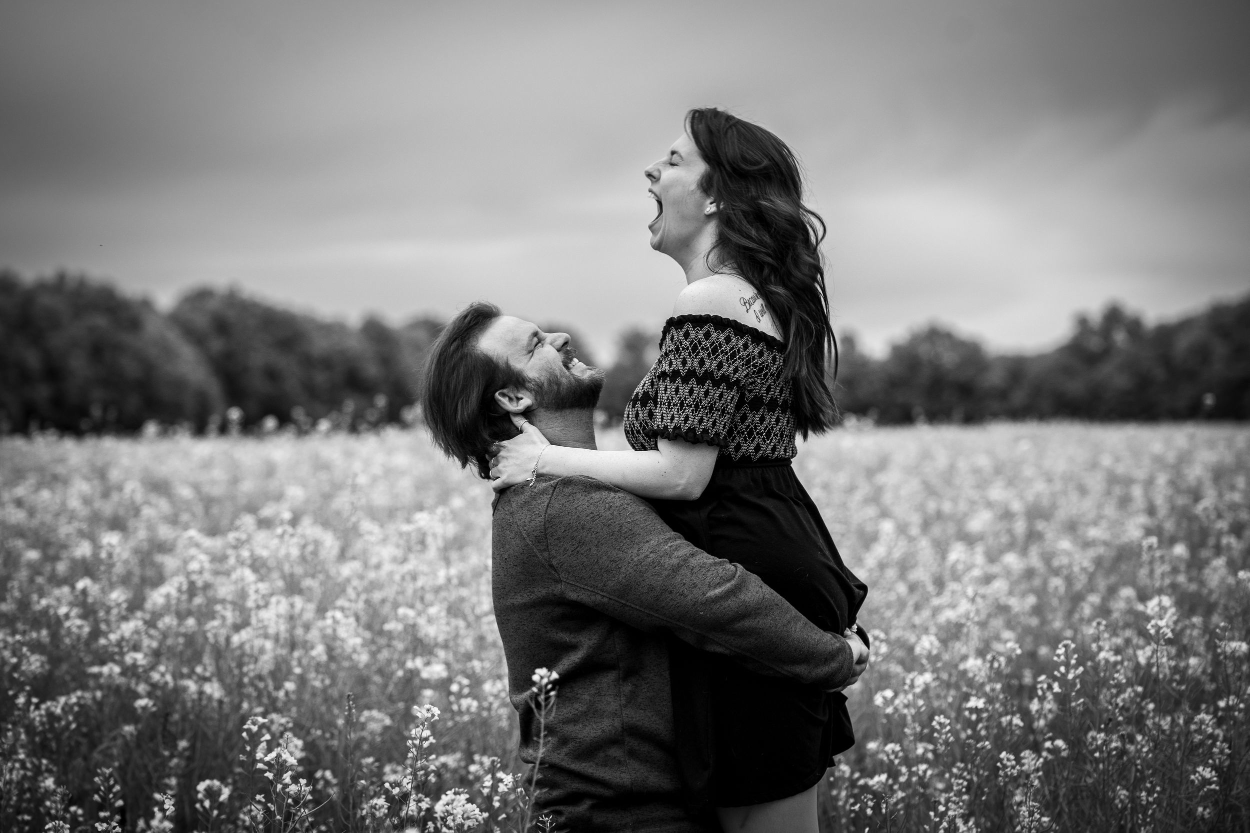 Black and white photo of people walking through a field of white flowers.