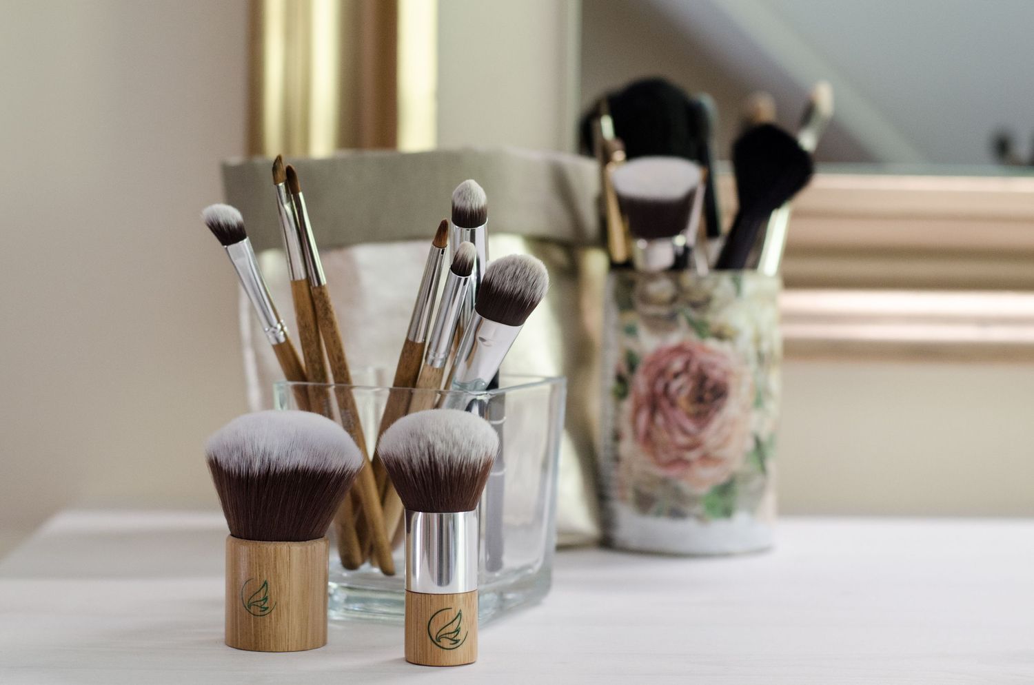 Professional makeup brushes and beauty products arranged on a bright windowsill.