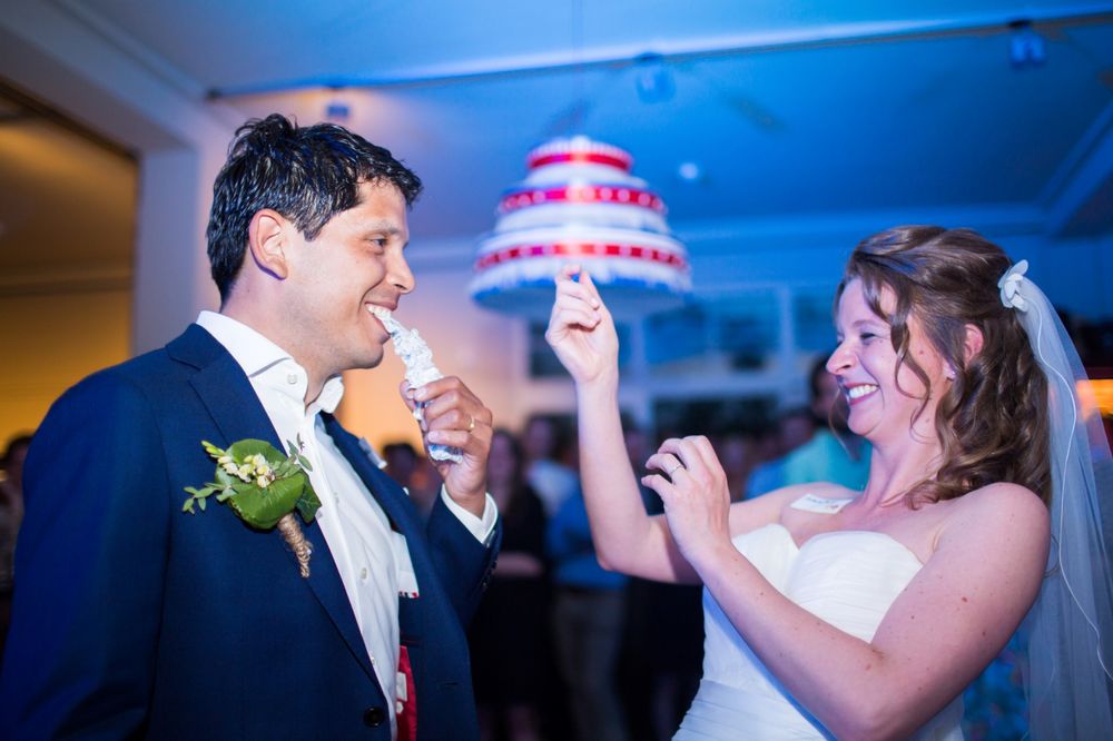 Couple dancing and celebrating at their wedding reception with festive lighting.