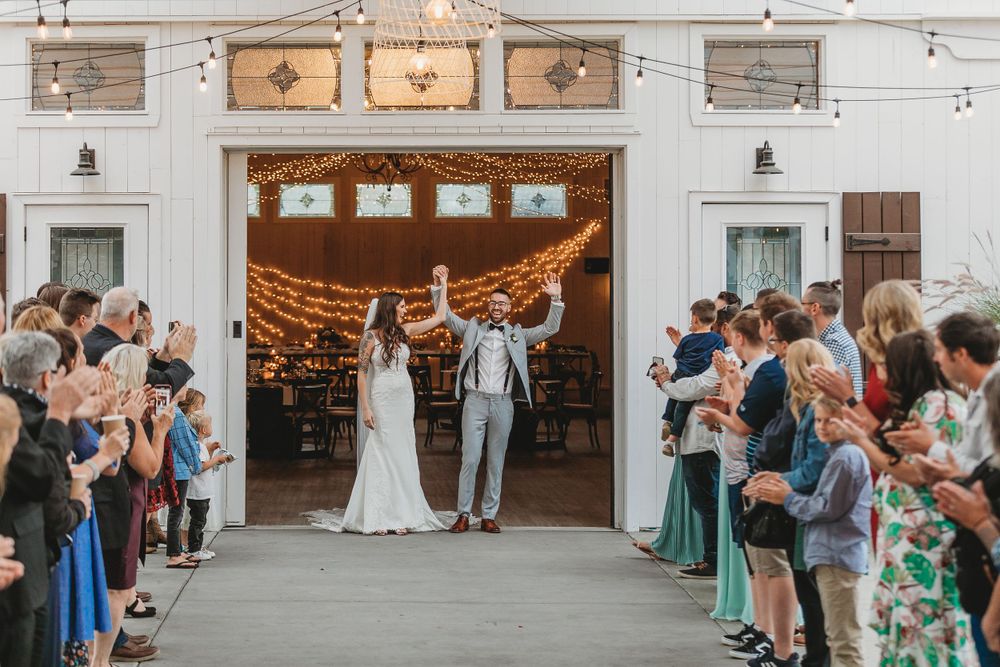 Wedding ceremony exit with guests lining the walkway under string lights.