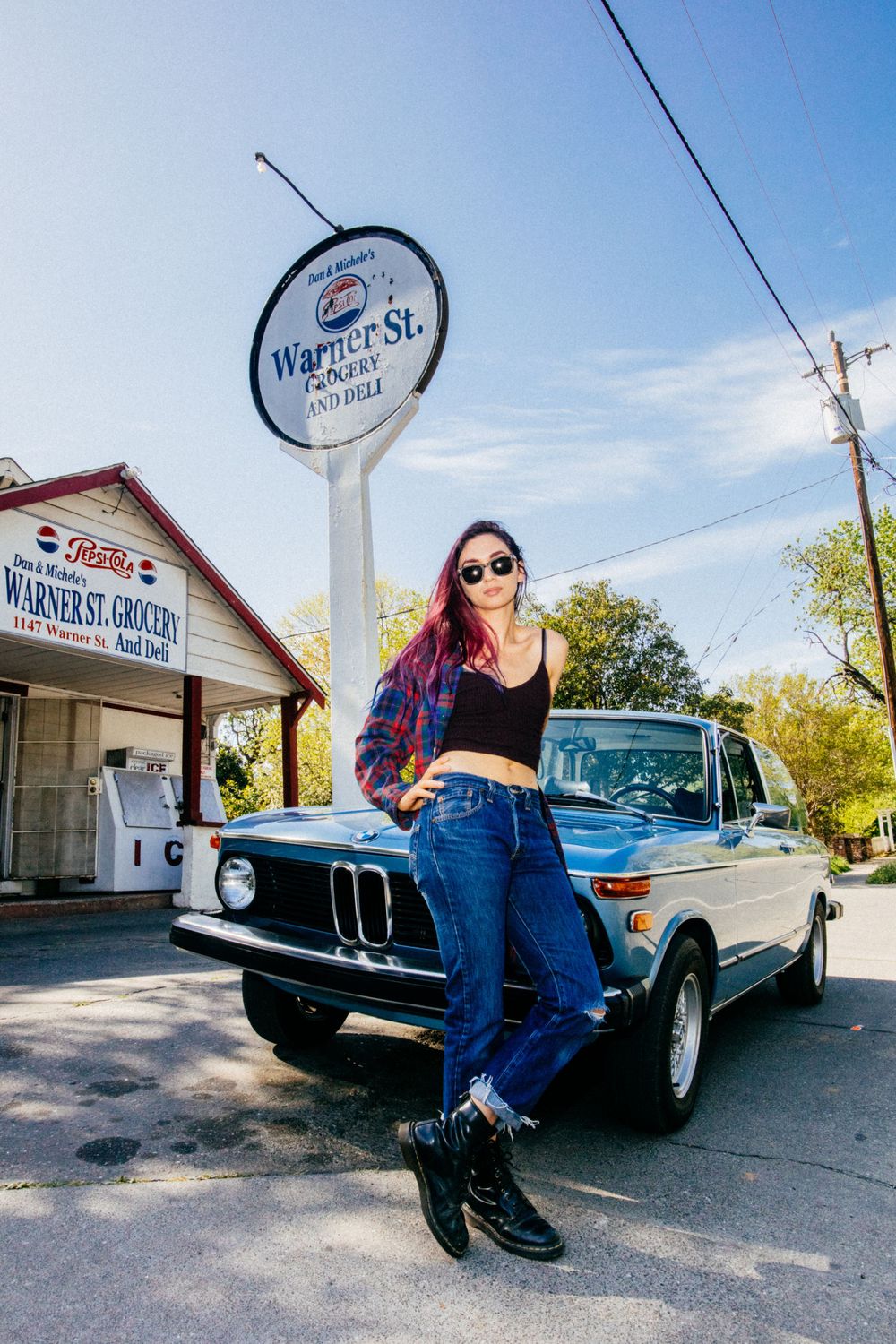 Classic BMW car parked at Wagner Street store with vintage signage in background.