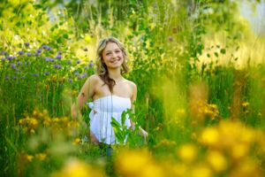 Golden sunlight illuminates a lush meadow filled with yellow wildflowers.