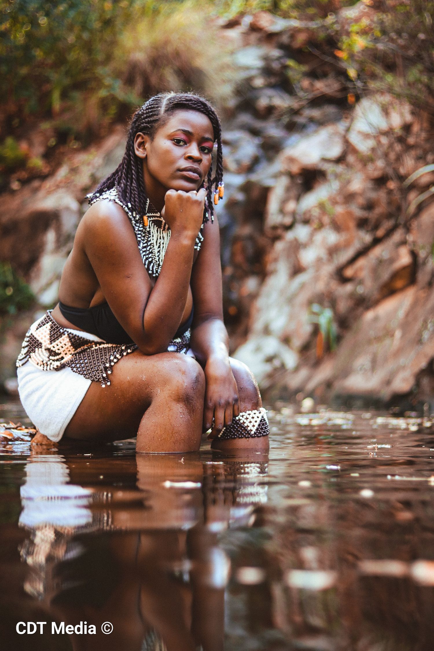Traditional photo of a girl in the river, being connected and one with nature and also proud of her South African Heritage day.