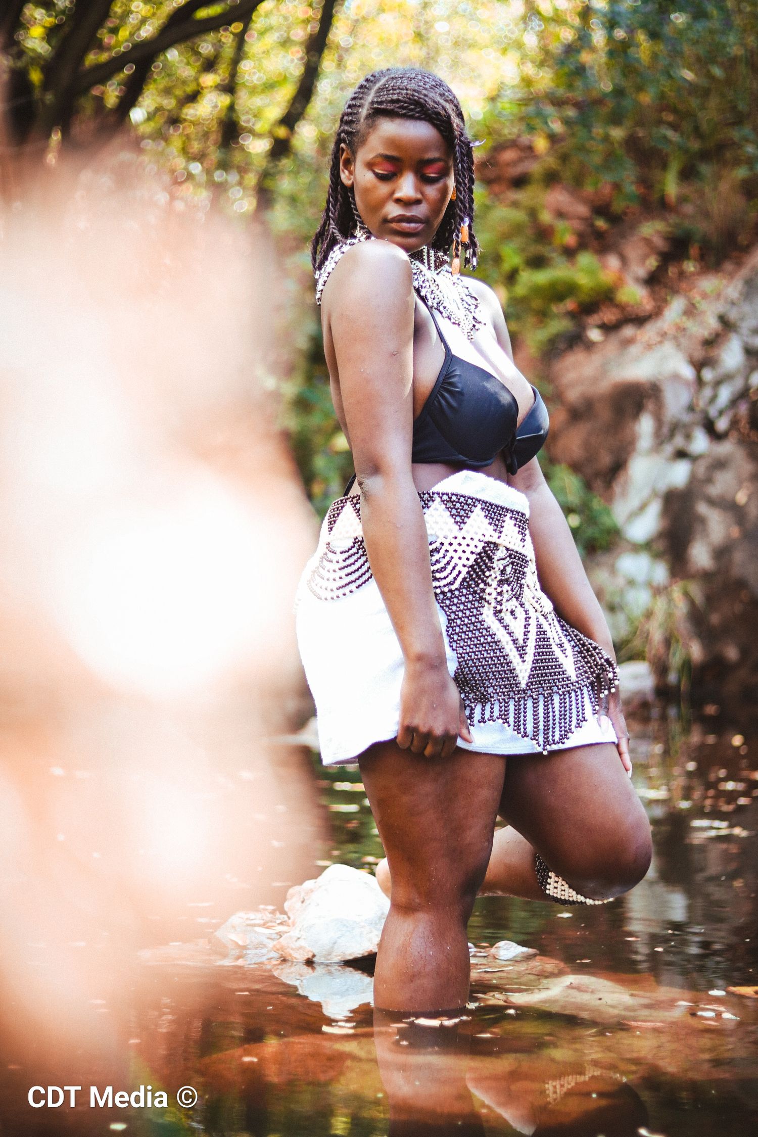 Traditional photo of a girl in the river, being connected and one with nature and also proud of her South African Heritage day.
