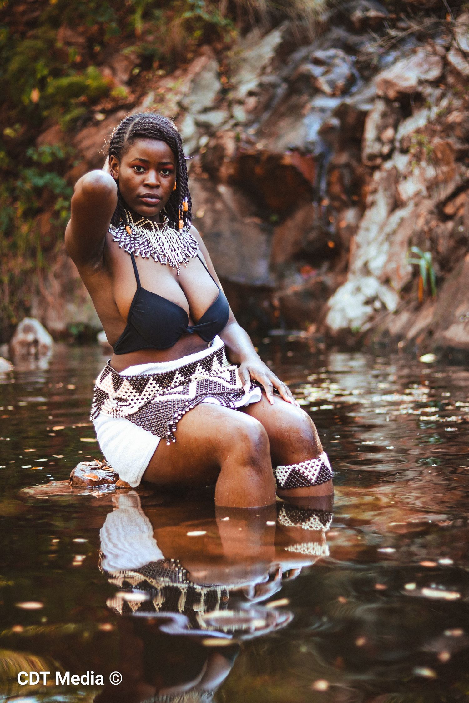 Traditional photo of a girl in the river, being connected and one with nature and also proud of her South African Heritage day.