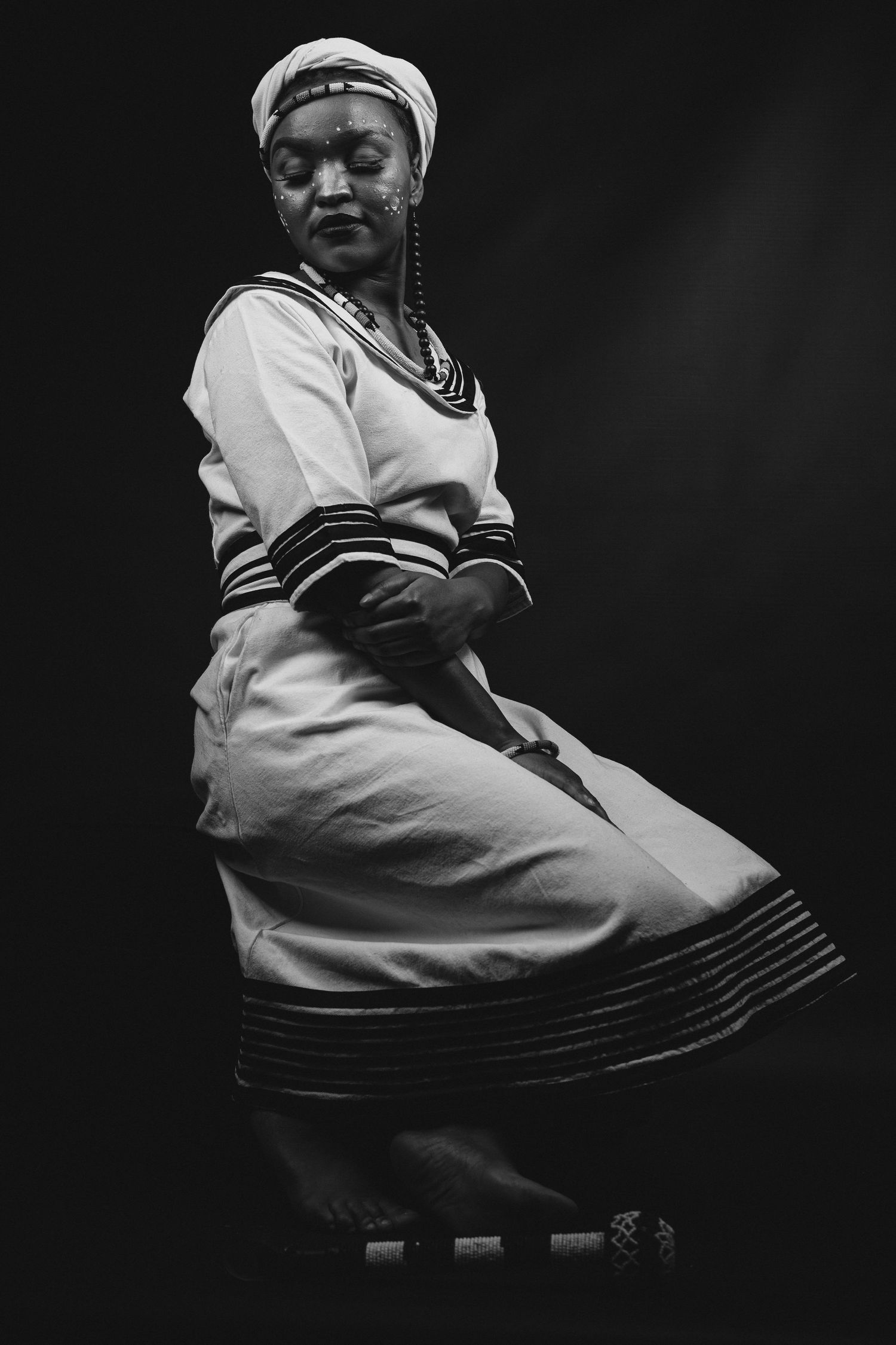 Studio shoot, of a lady celebrating her Xhosa heritage, dramatic and story telling images, black and white photo.