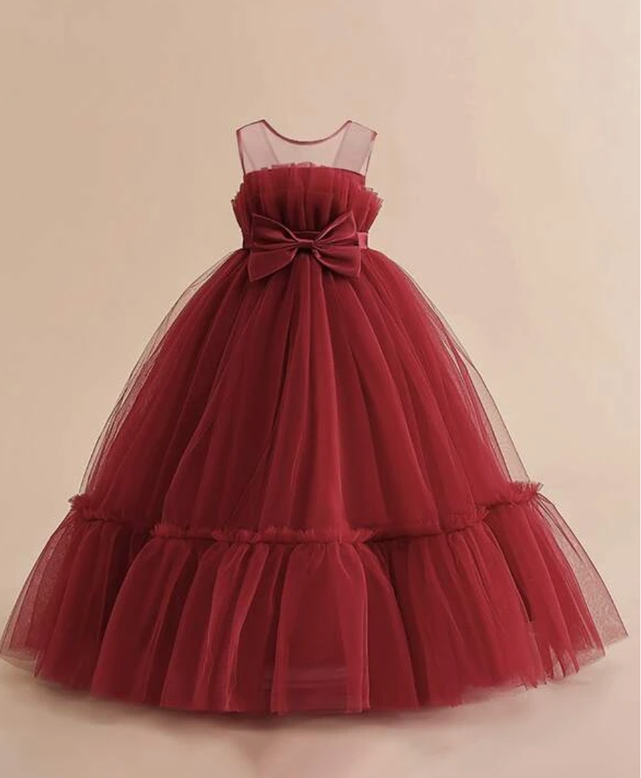 Deep red tulle ball gown with sheer neckline and large bow accent.