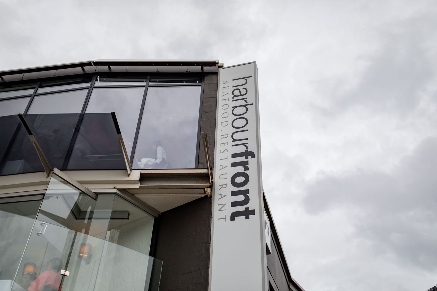 Modern building exterior showing Harbour Front signage against cloudy sky.