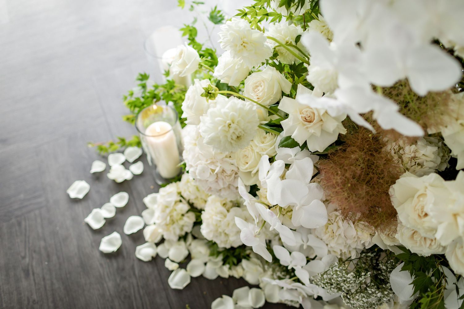 Close-up of white roses and mixed flowers in an elegant wedding arrangement.