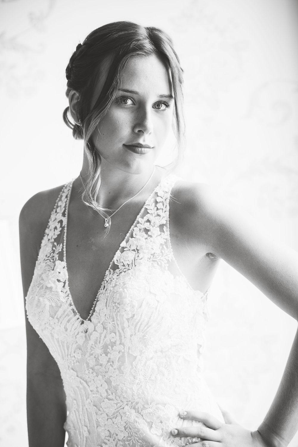 Classic black and white bridal portrait showing delicate lace wedding dress with v-neckline.