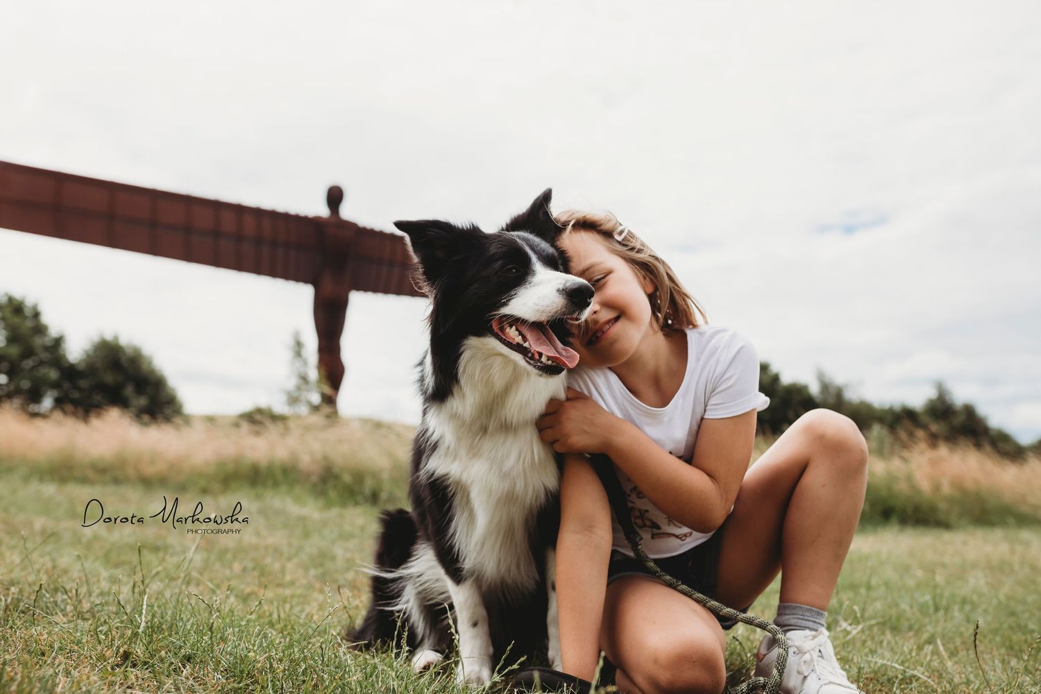 Border collie and owner sharing a playful moment outdoors in a grassy field.