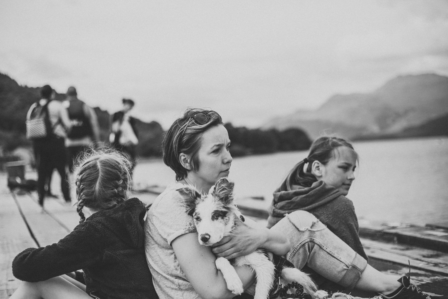 People enjoying a boat ride on a lake with mountains in the background.