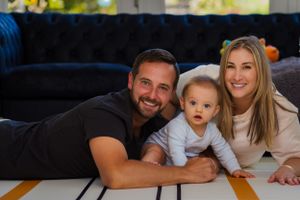 an adorable baby steals the show in this picture with his parents capturing playing with each other on the floor