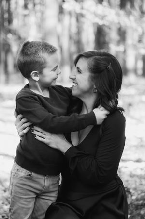a mother embraces her son and smiles