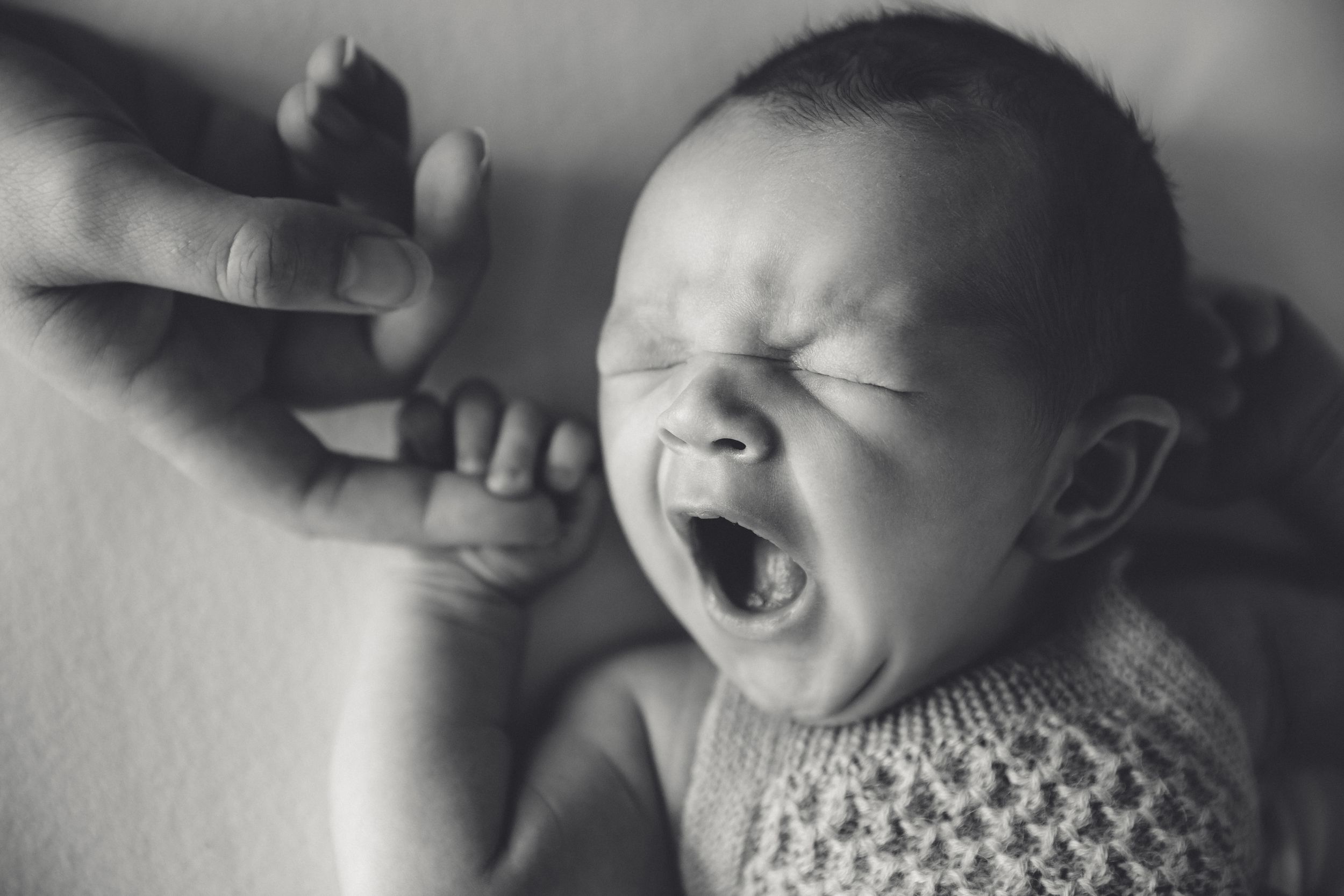 Close-up of newborn sleeping peacefully with baby yawns during an in-home session. Westport NZ
