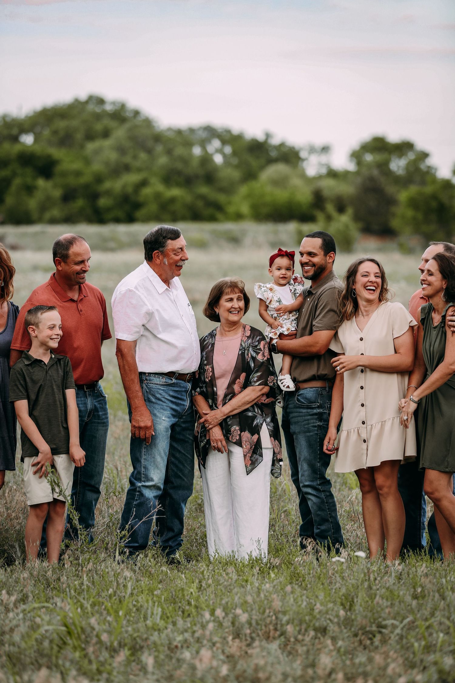 big family laughing in field