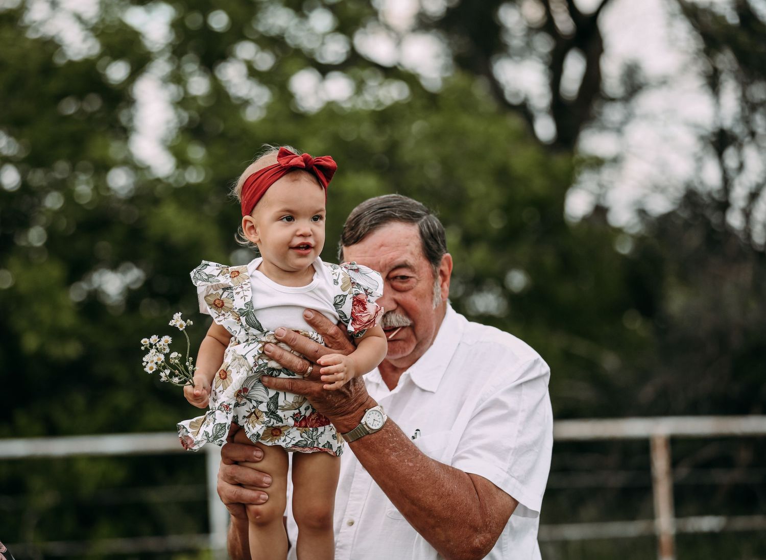 grandpa holding up a baby