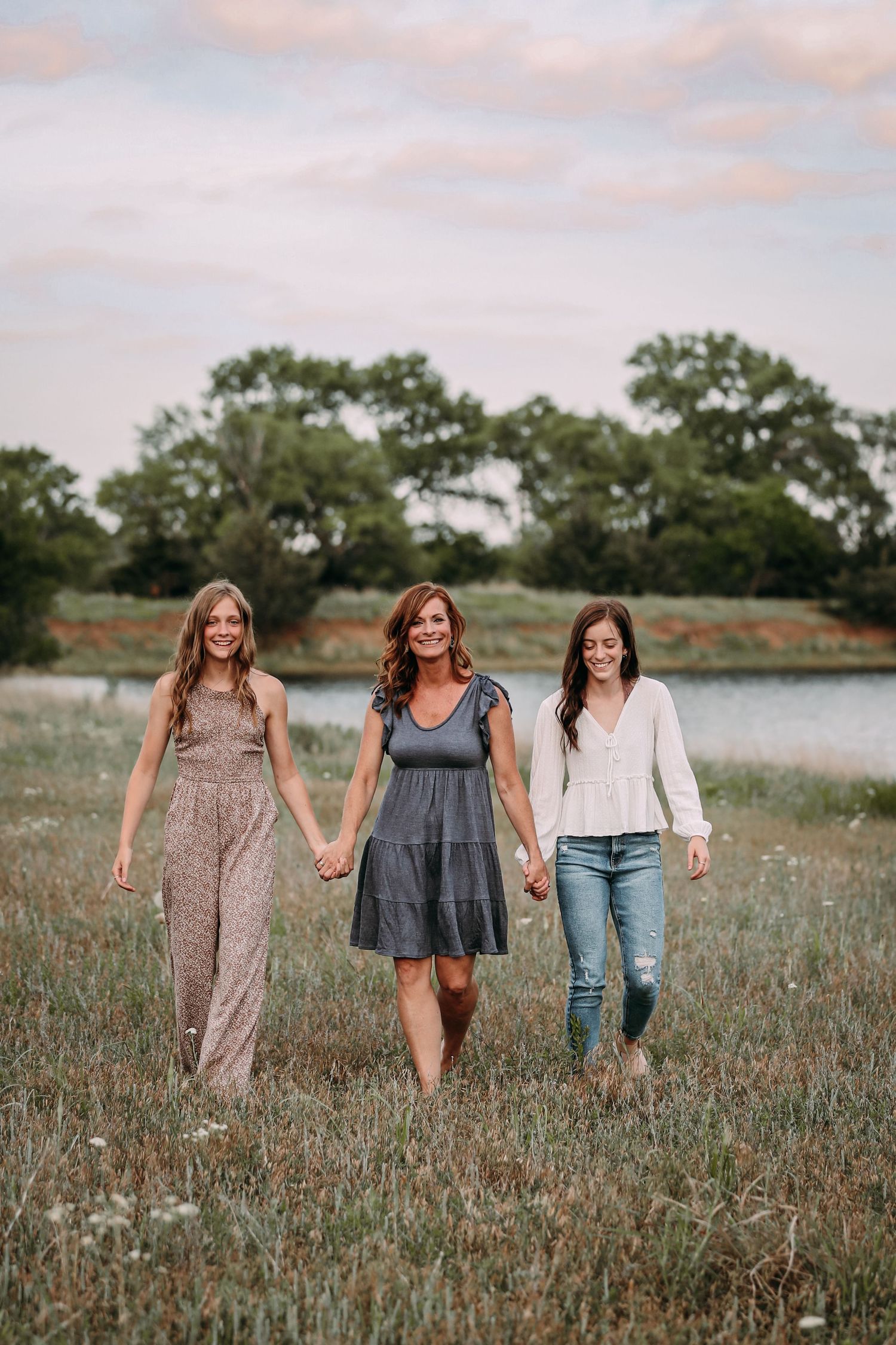 sisters and mom walking in field