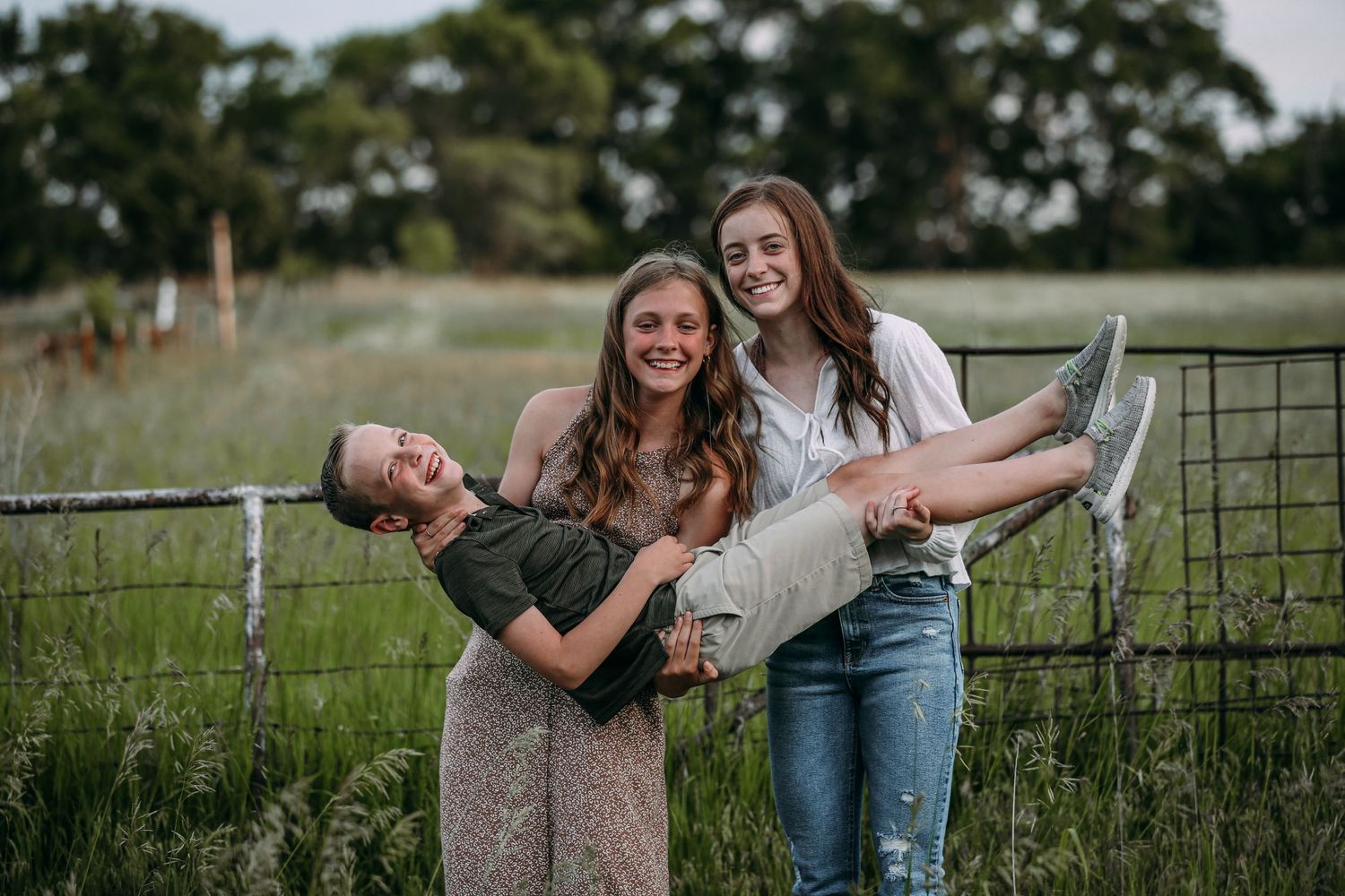 two sisters holding their little brother
