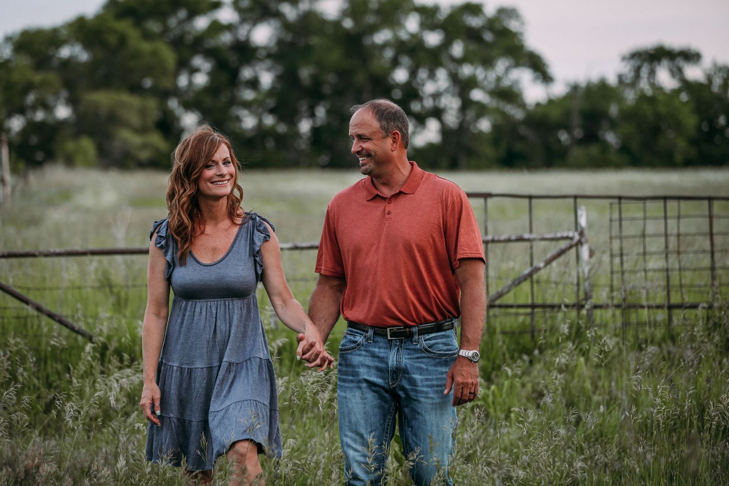 mom and dad holding hands in field