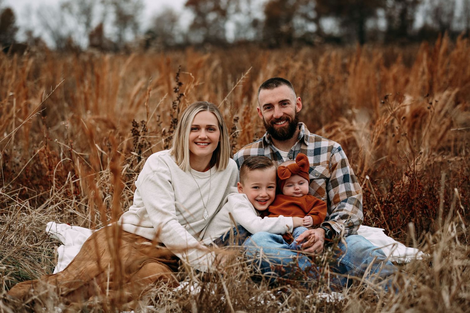 family of 3 in tall orange grass