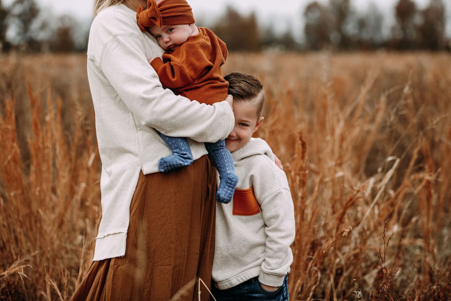 brother sister and mom in field