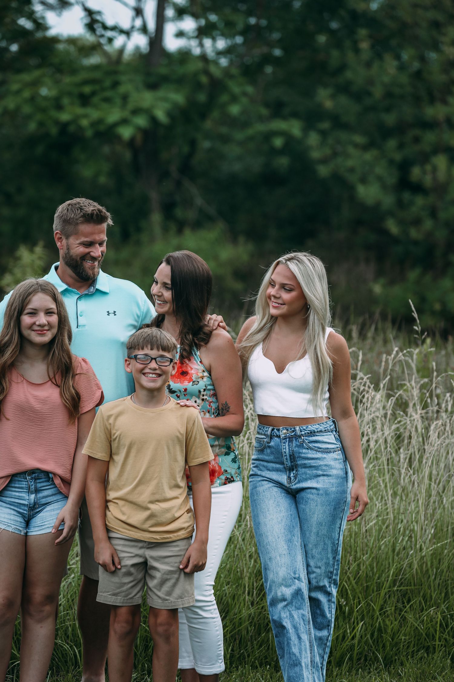 family laughing in tall grass