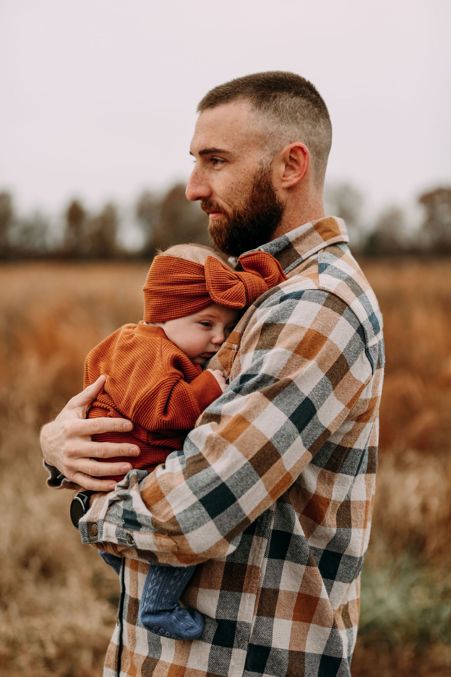 dad holding baby in field