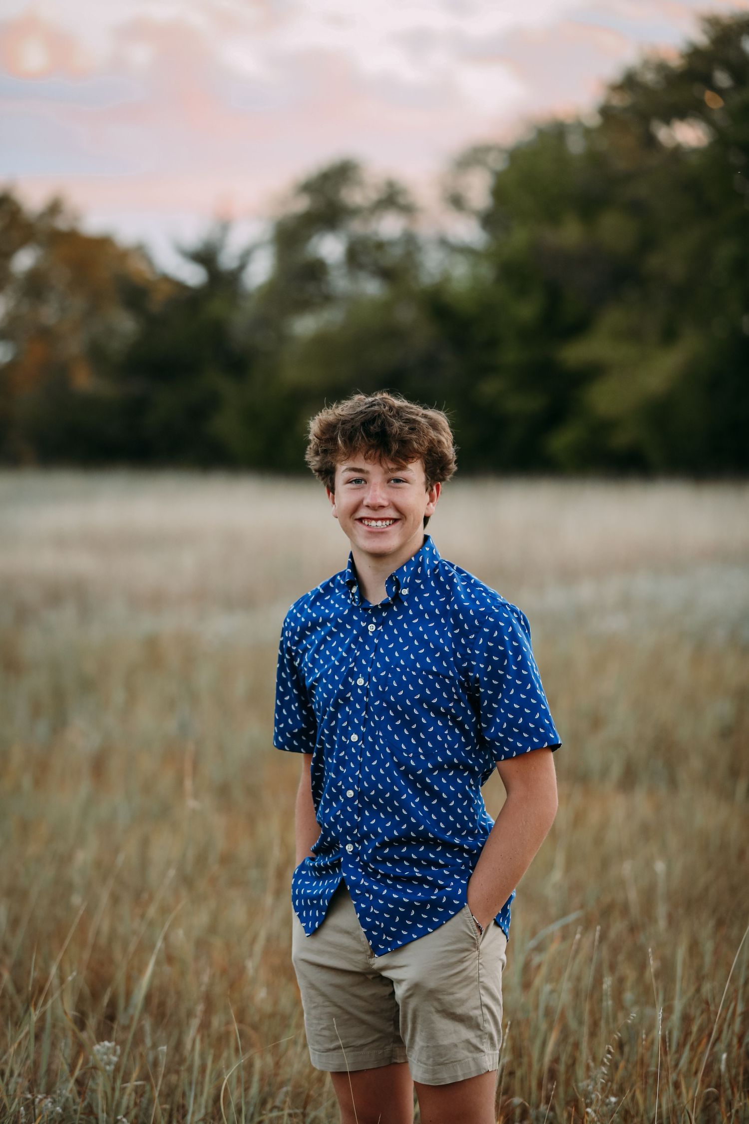 a young boy smiling in a field